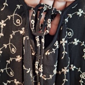 Black embroidery blouse. 3/4 long sleeves . With a small opening in the front .